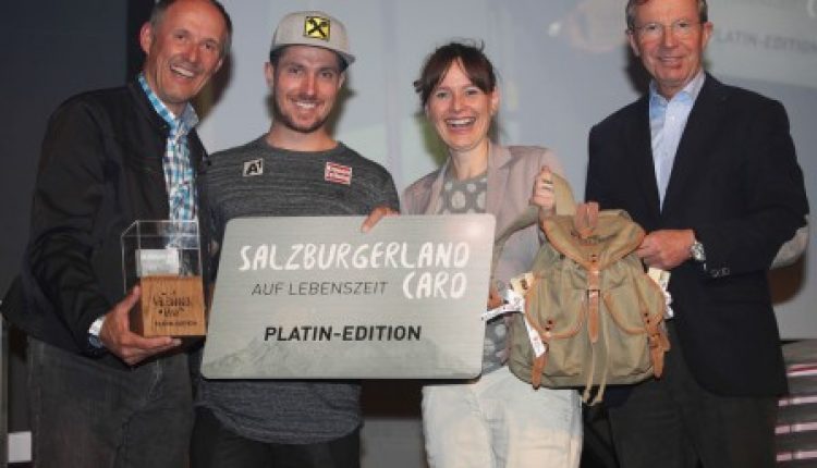 Vier lächelnde Menschen halten auf einer Bühne Preise und ein Schild mit der Aufschrift SalzburgerLand Card Platin-Edition.