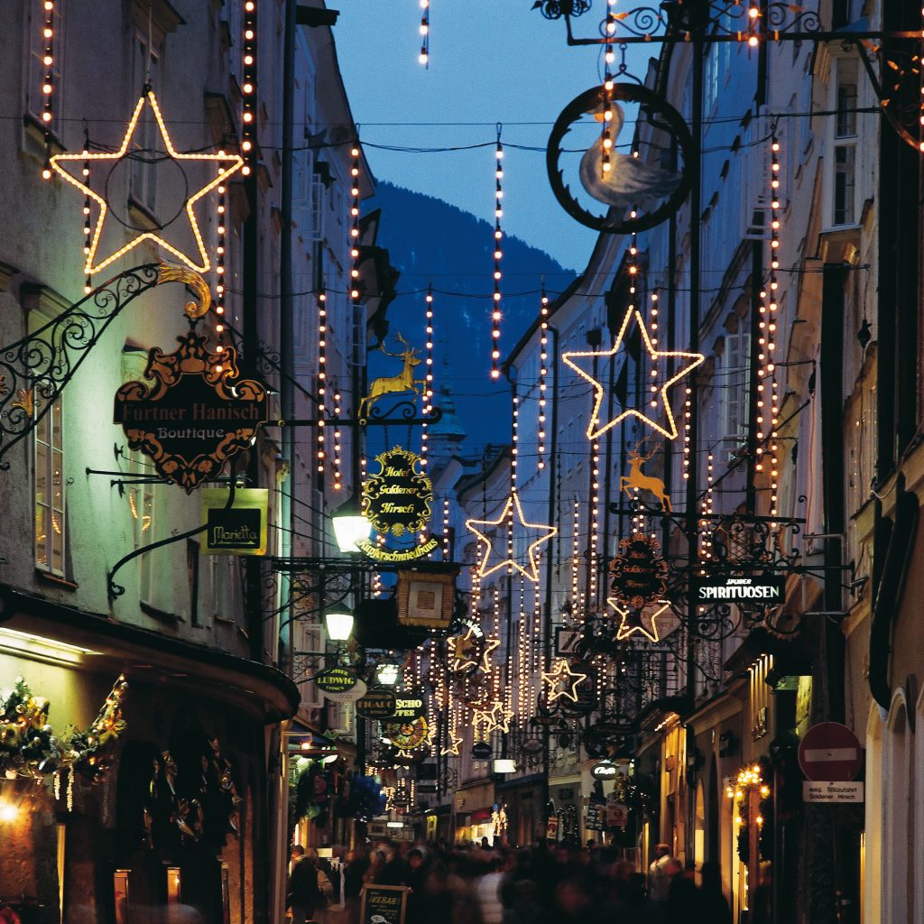 Eine festliche Straße in Asien ist abends mit leuchtenden Lichtersternen und Ornamenten geschmückt.