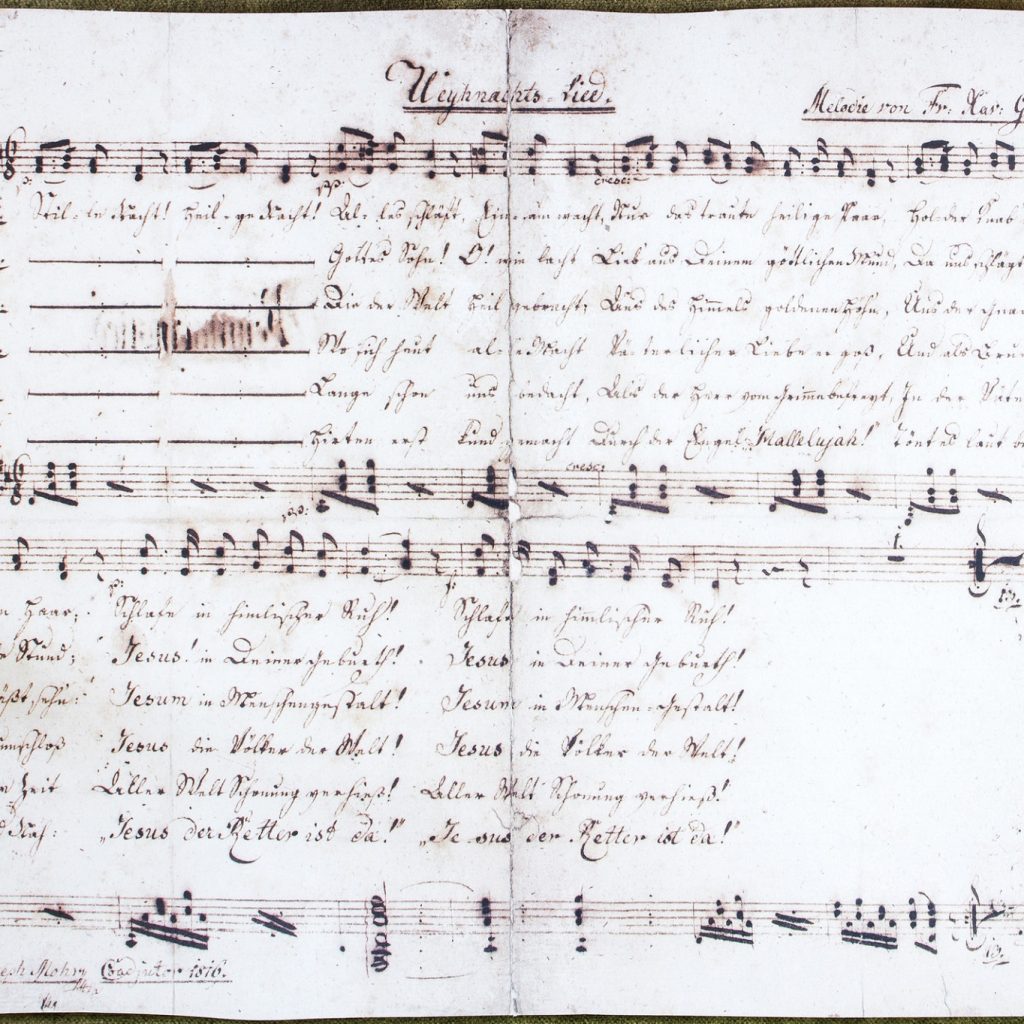 Handgeschriebene Noten und deutsche Texte auf gealtertem Papier mit sichtbaren Noten und Notenlinien.