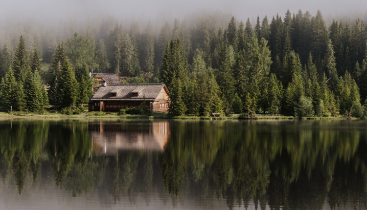 Bergsee in Nebelstimmung, am See spiegelt sich die Hütte